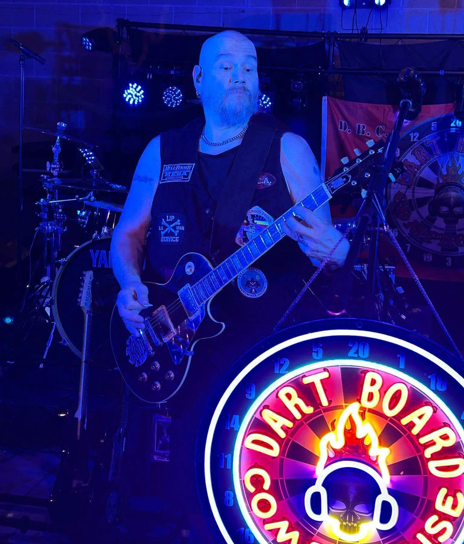 DBC guitarist performing at a mic stand